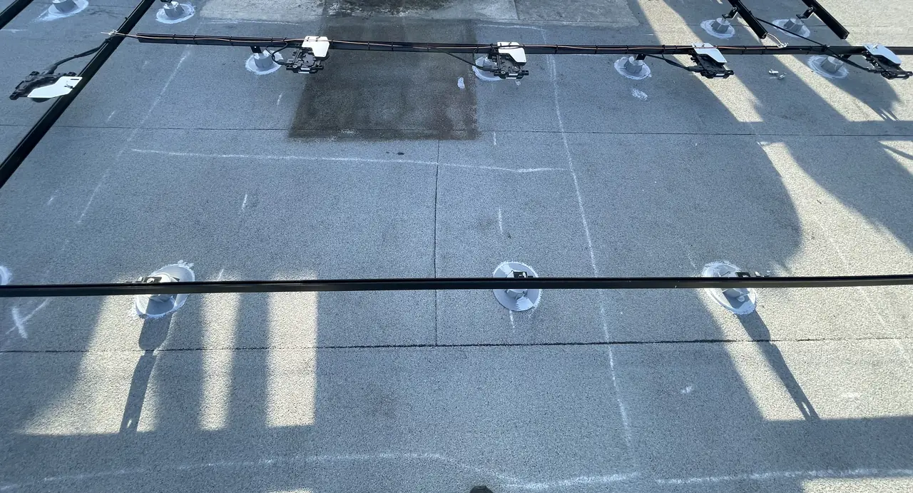 Mounting rails set out in rows across a flat roof before the modules go down, Atwater Village, Los Angeles