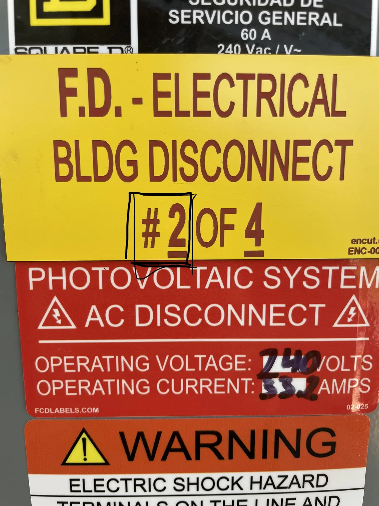 A yellow fire-department disconnect placard on photovoltaic service equipment, East Los Angeles