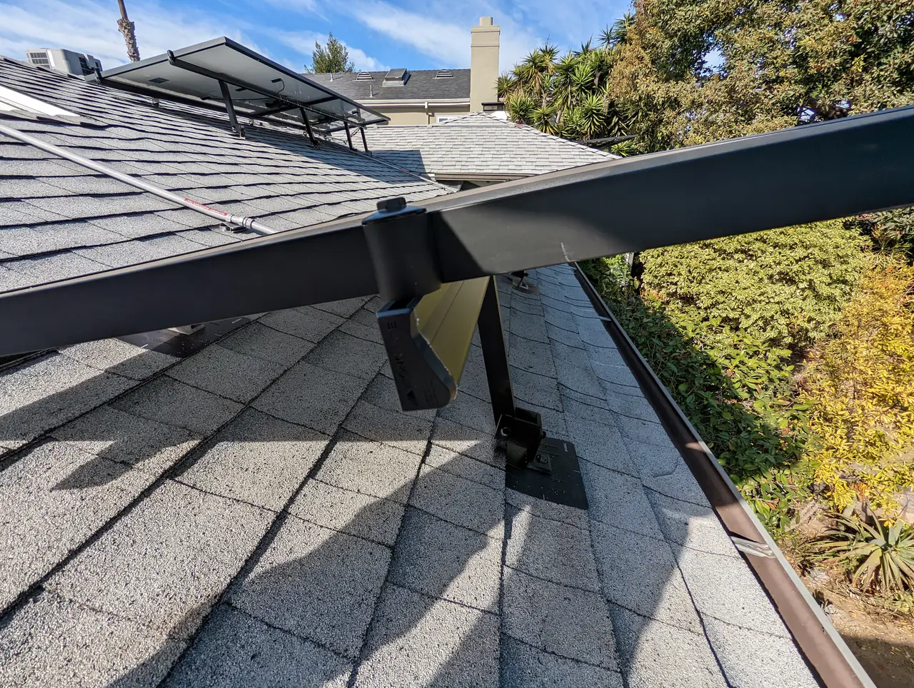 Mounting rails set along the ridge of a composition shingle roof before the modules go on, Mid-City, Los Angeles