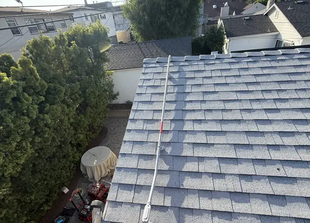 A composition shingle roof carrying mounting rails with the surrounding neighborhood beyond, Westchester, Los Angeles