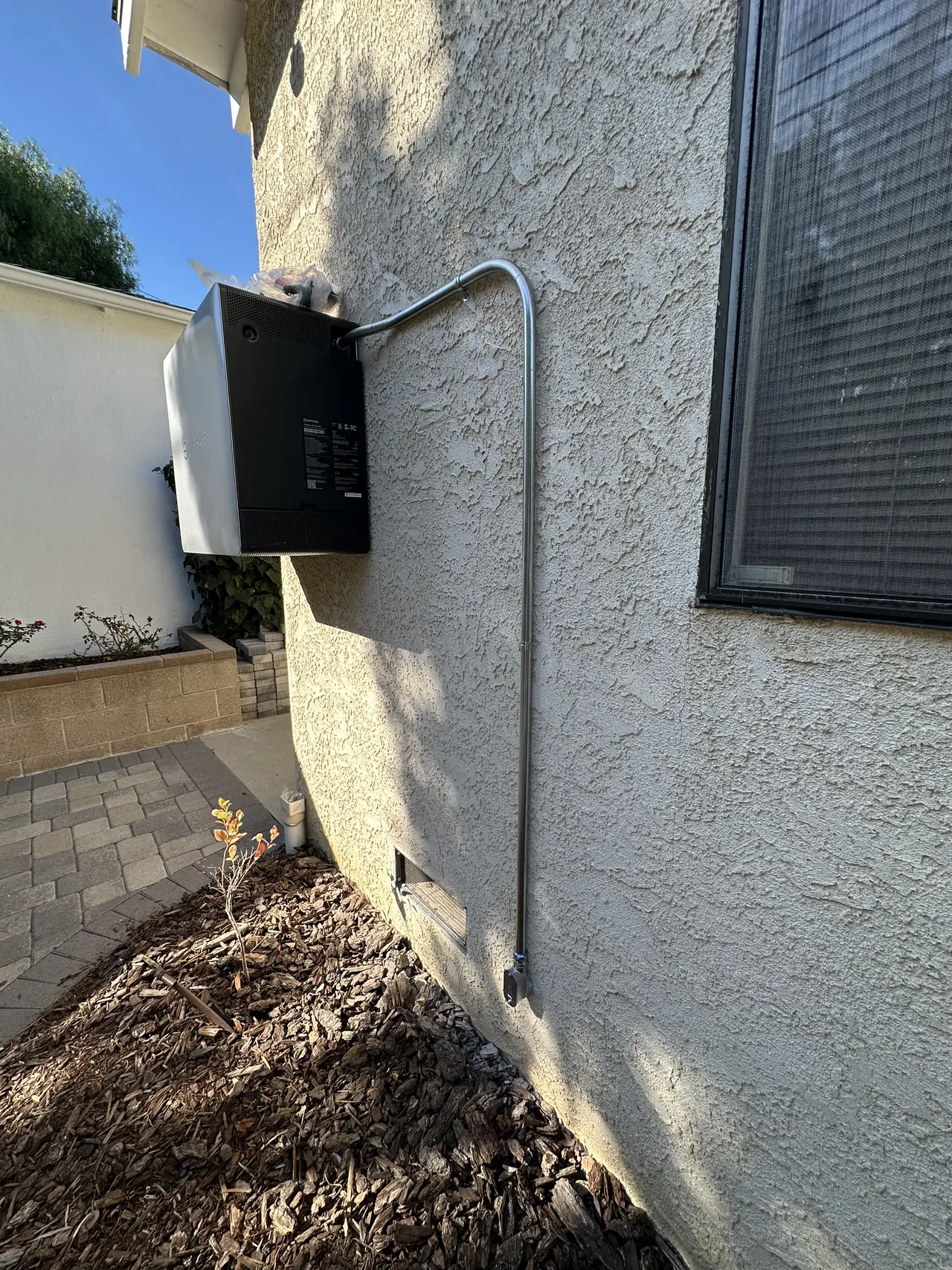 A battery enclosure mounted on the exterior wall of a house, Westchester, Los Angeles