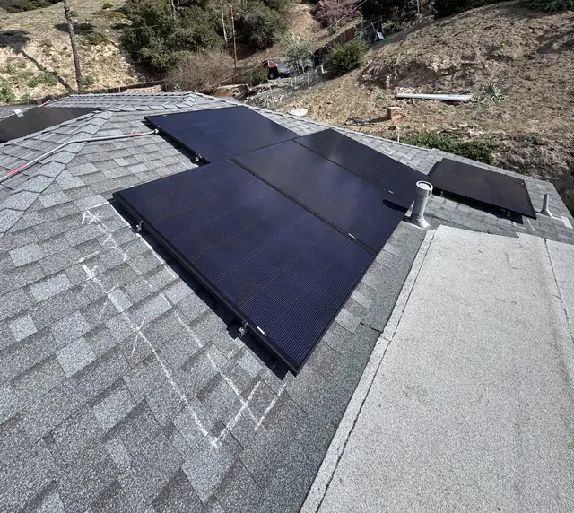 Solar modules on a composition shingle roof with the hillside and sky beyond, Glassell Park, Los Angeles