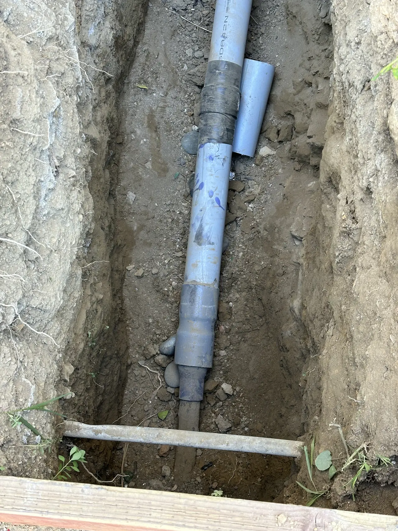 Conduit laid in an open trench alongside a wall, Hollywood Hills, Los Angeles