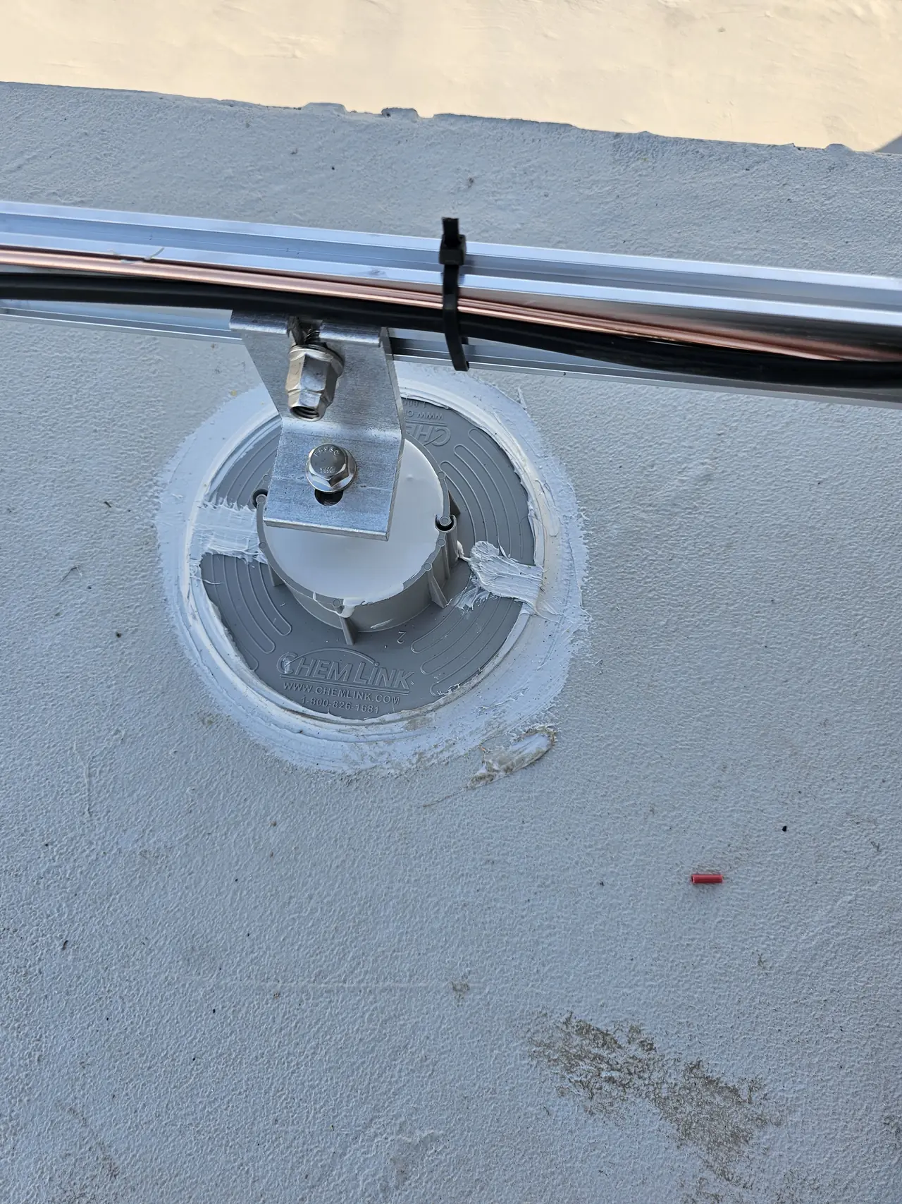 A mounting foot sealed into a low-slope roof covering, West Los Angeles