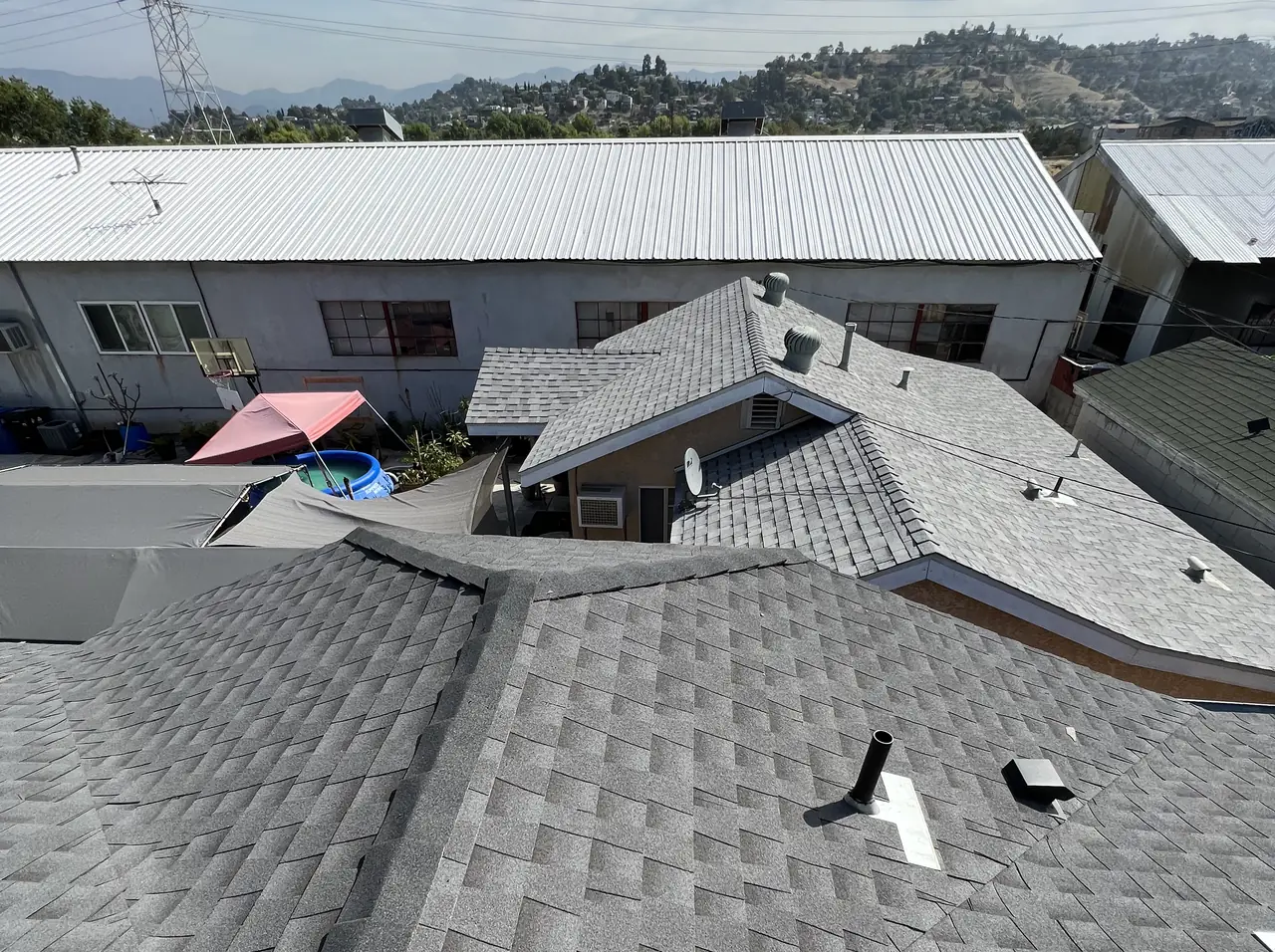Composition shingle roof planes with the surrounding neighborhood and hills beyond, Lincoln Heights, Los Angeles