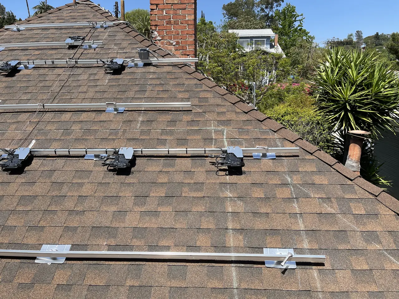 Mounting rails and micro-inverters fixed to a composition shingle roof before the modules go on, Echo Park, Los Angeles