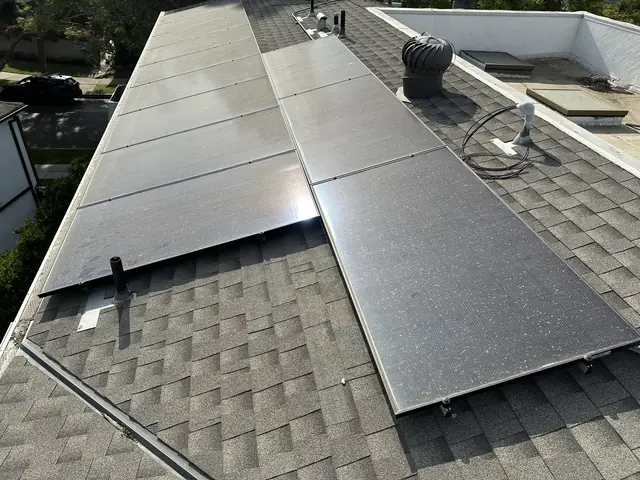 Two rows of solar modules running along the ridge of a composition shingle roof, Palms, Los Angeles