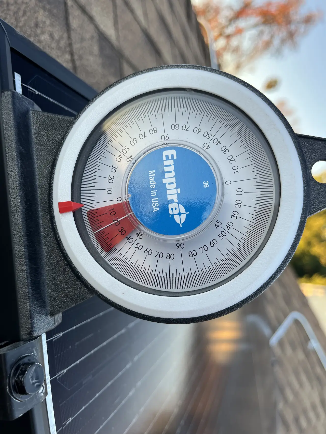 An inclinometer standing on a solar module to read the tilt of the array, Mission Hills