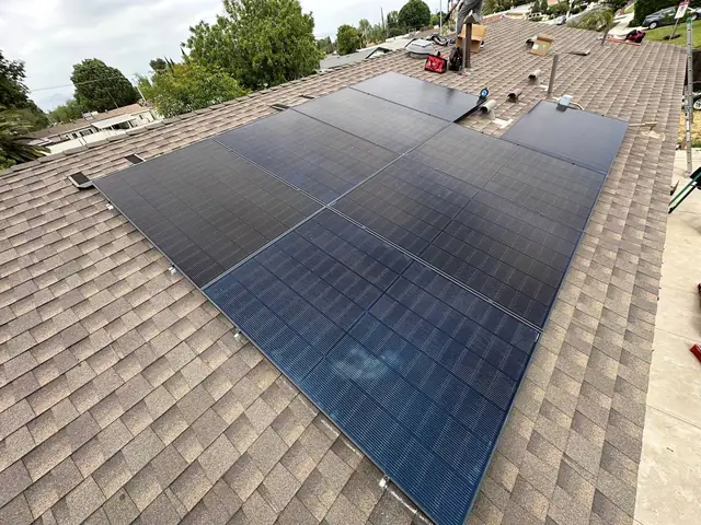 A large solar array covering a wide brown composition shingle roof plane, North Hills, Los Angeles