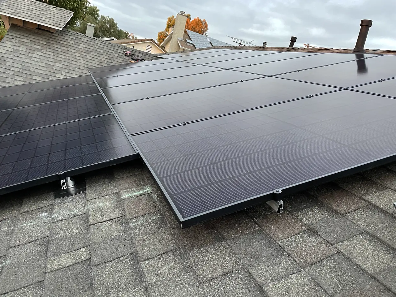 Solar modules meeting at the junction of two roof planes on a shingle roof, North Hills, Los Angeles