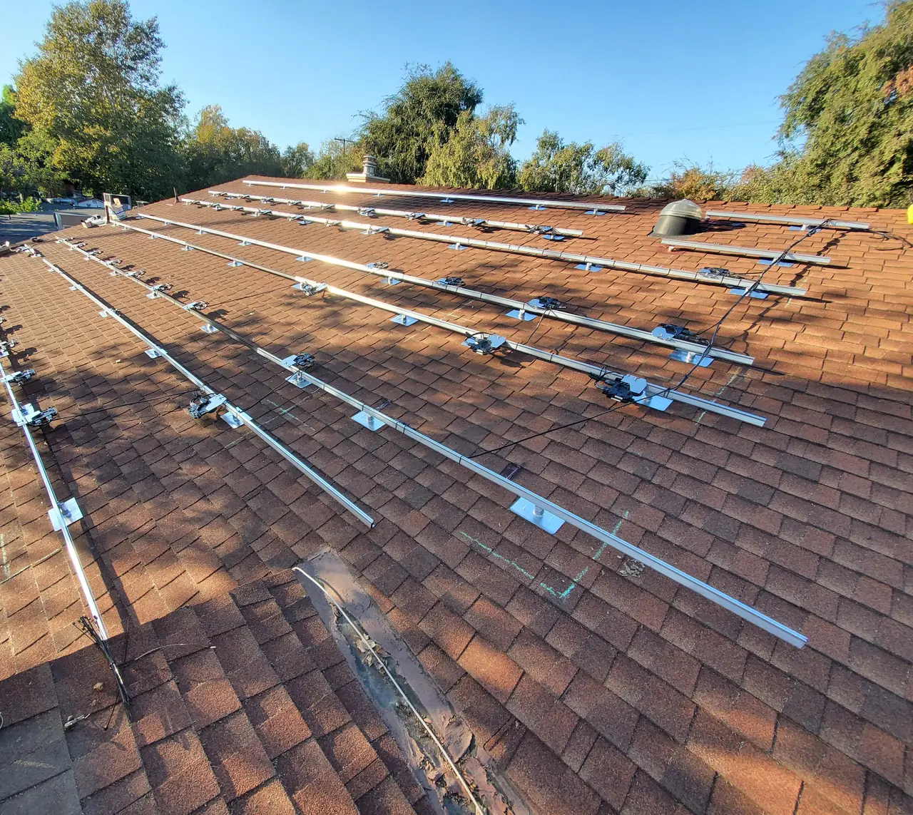 Mounting rails laid out in long parallel runs across a wide shingle roof, North Hollywood