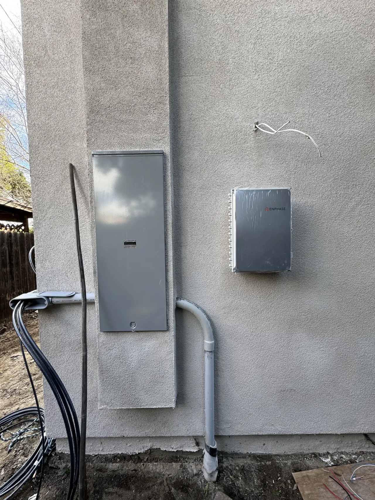 New electrical panel and solar combiner mounted on an exterior wall beside a patched stucco band, North Hollywood