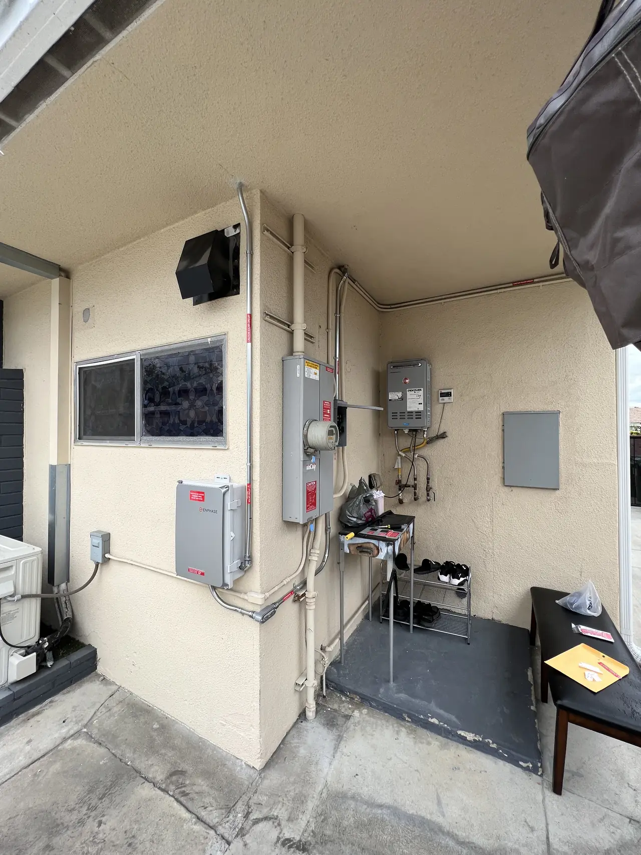 Electrical enclosures and conduit runs along an exterior wall under a patio roof, North Hollywood
