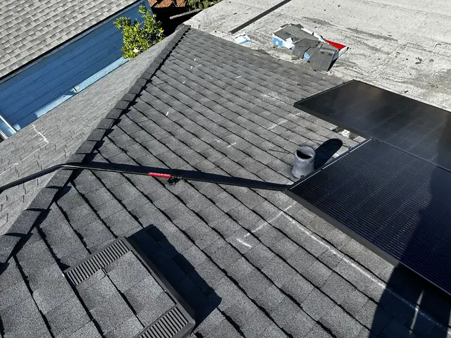 Solar modules on two roof planes meeting at a hip, with a flat roof section beyond, North Hollywood