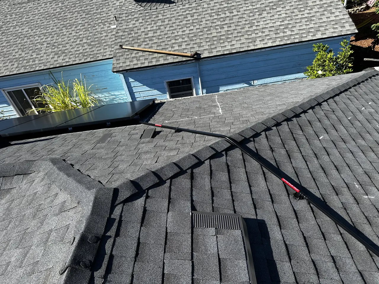 A hip and valley junction on a composition shingle roof with conduit crossing it, North Hollywood
