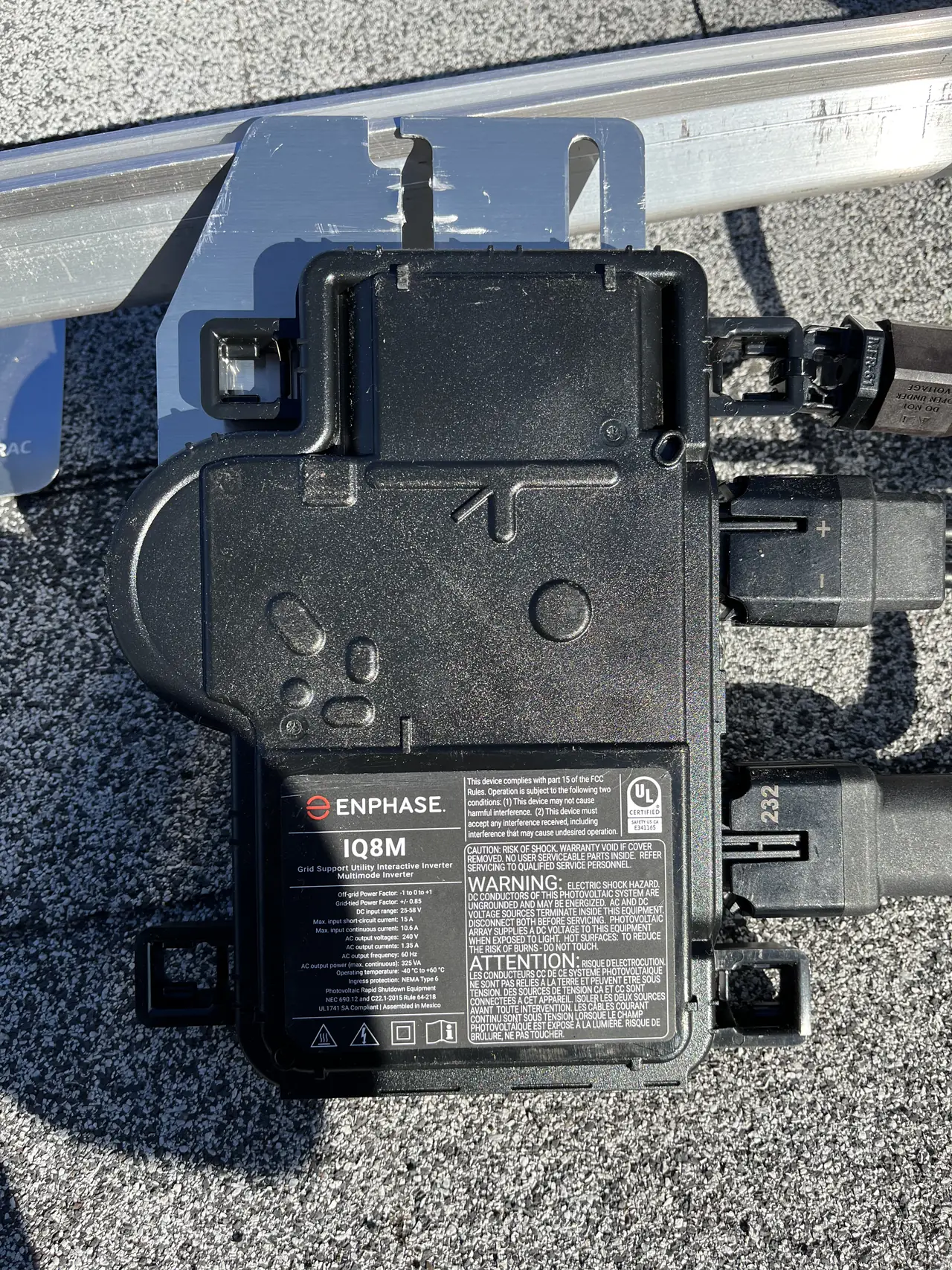 Enphase IQ8M microinverter mounted on a rail beneath a module, North Hollywood