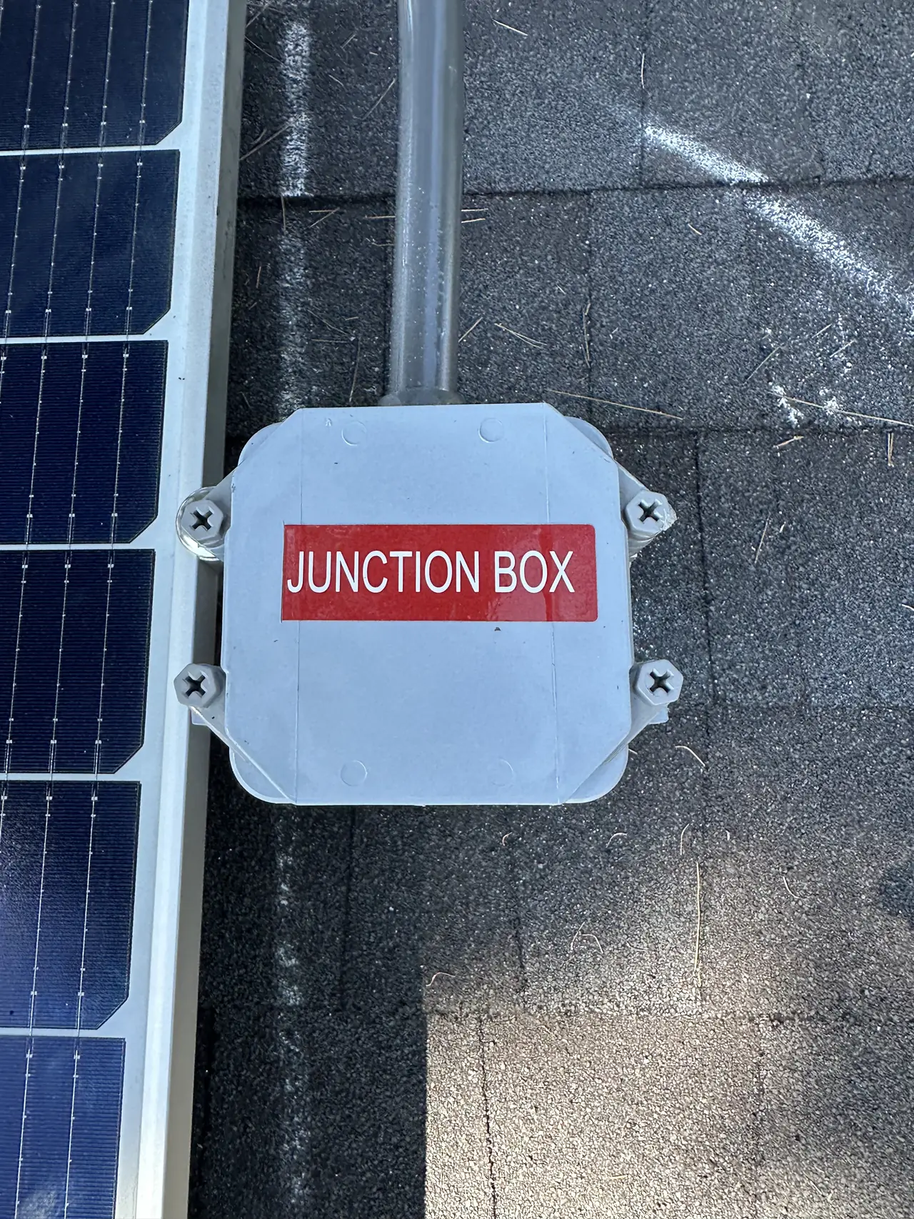 Roof junction box on shingle beside the edge of a solar module, North Hollywood