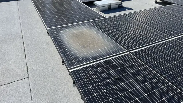 A solar array on a flat roof with one module showing a large discoloured patch, North Hollywood