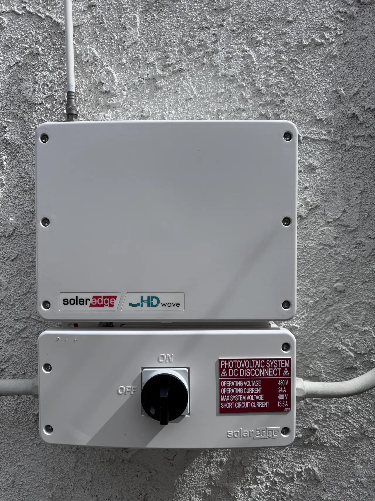Solar equipment enclosure and disconnect mounted on a stucco wall, North Hollywood