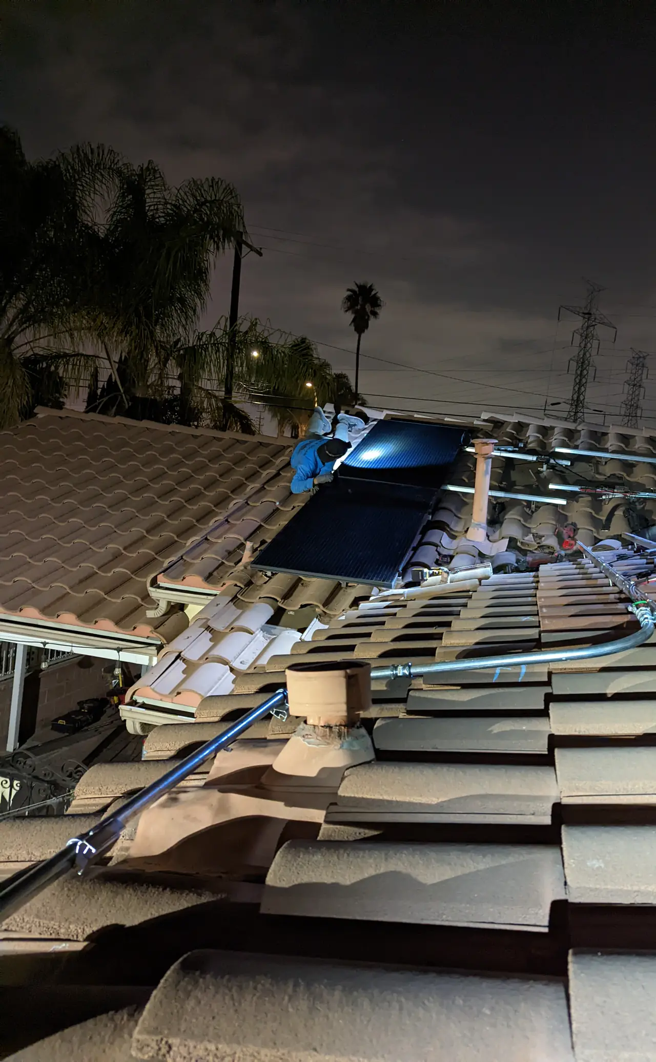 Night installation on a concrete tile roof with rails going in, North Hollywood