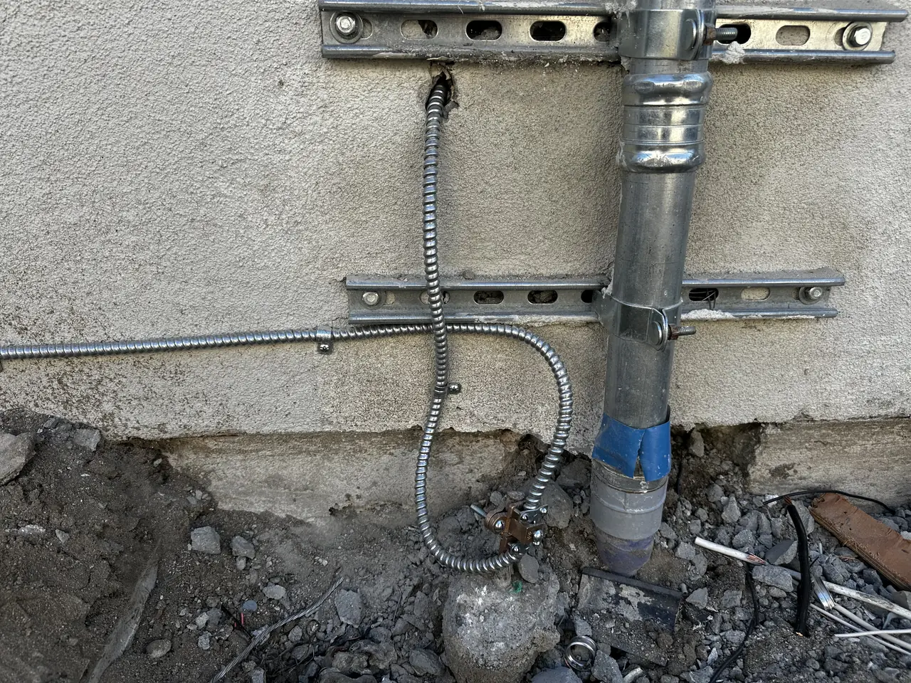 Flexible conduit entering a stucco wall at ground level, North Hollywood