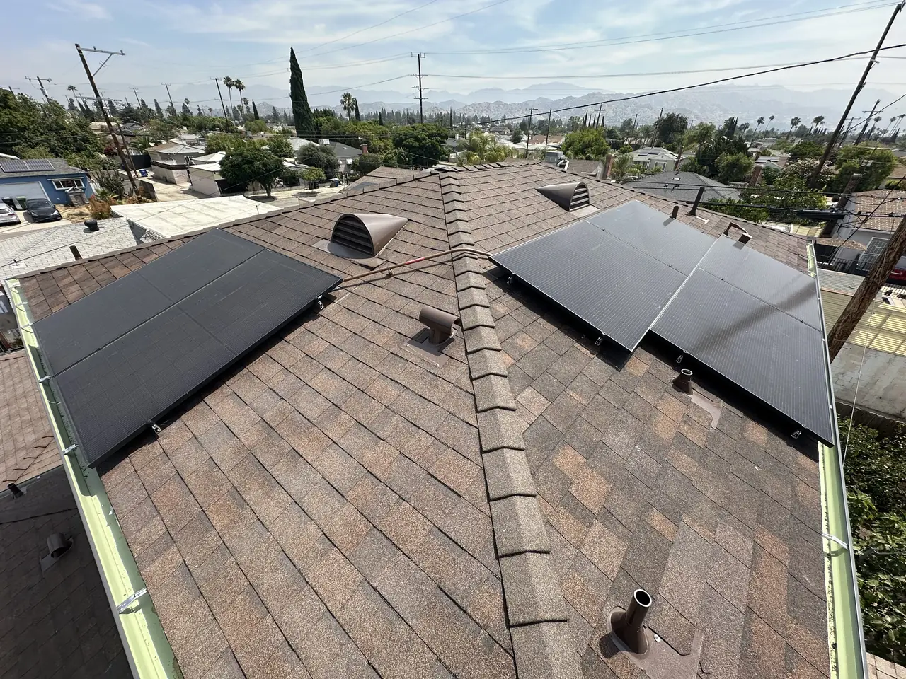 Two sections of a solar array meeting at the hip of a new shingle roof, North Hollywood