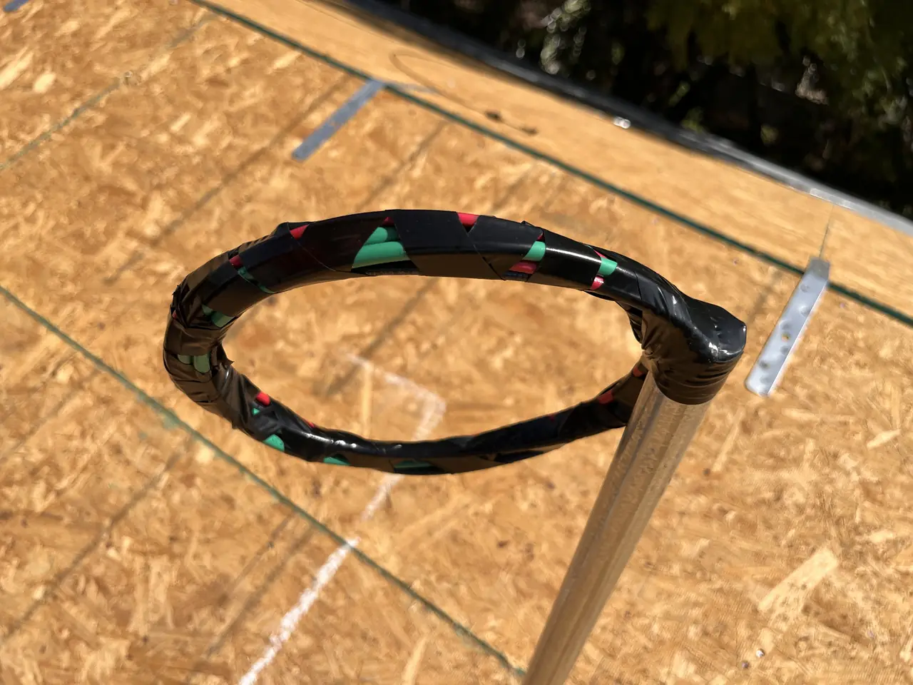 A taped coil of electrical conductor standing up through bare roof sheathing on a new build, North Hollywood