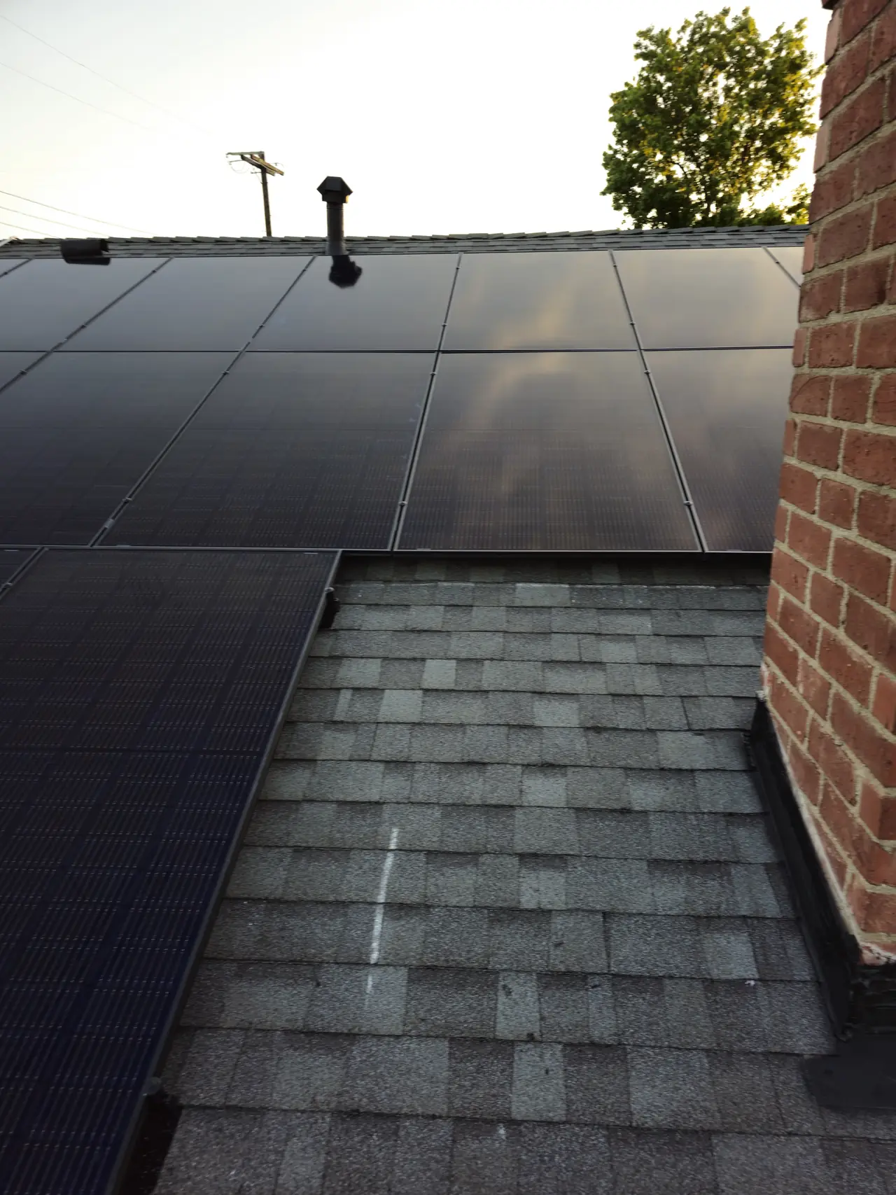Solar modules meeting a brick chimney on a hip roof, North Hollywood