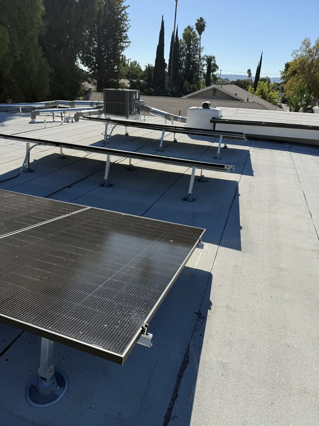Tilt legs and rails on a flat roof beside a rooftop air conditioning unit, Northridge