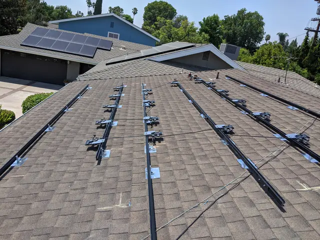 Mounting rails across a composition shingle roof with a neighbouring array beyond, Northridge