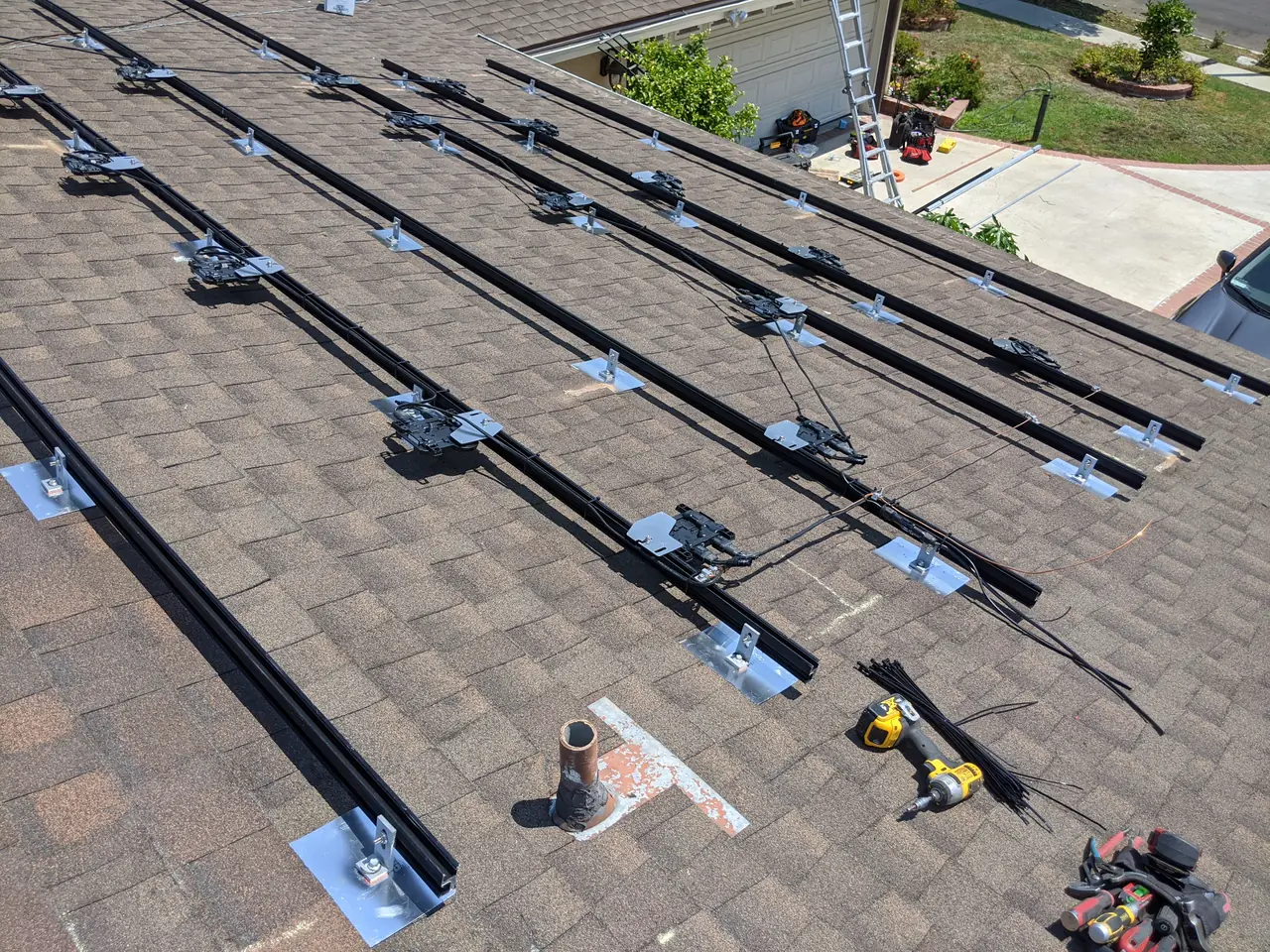 Rails and mounts laid out in rows across a shingle roof, Northridge