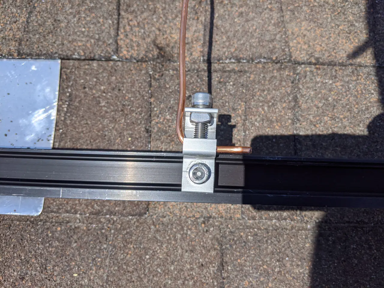 Bonding conductor clamped to a mounting rail on a shingle roof, Northridge