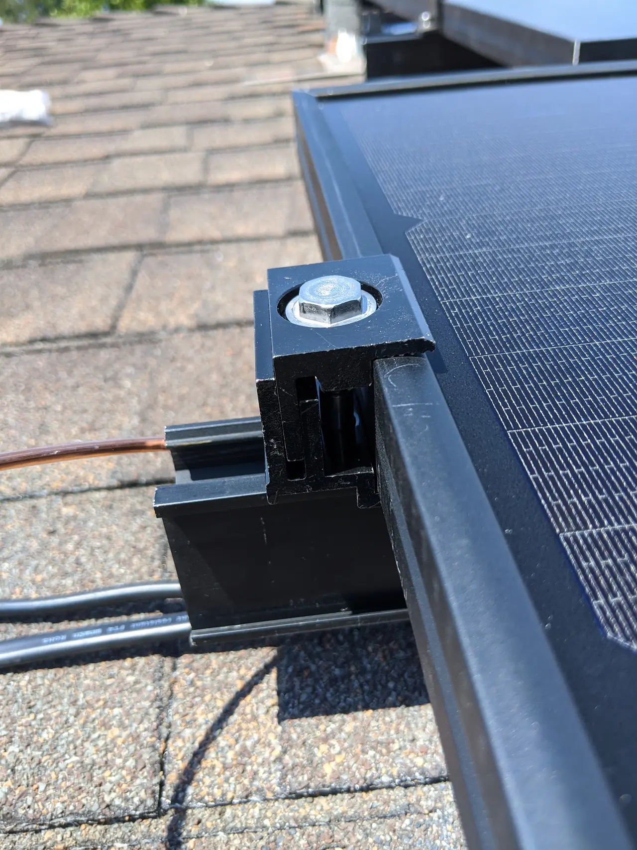 Module edge seated on a rail above a microinverter, Northridge