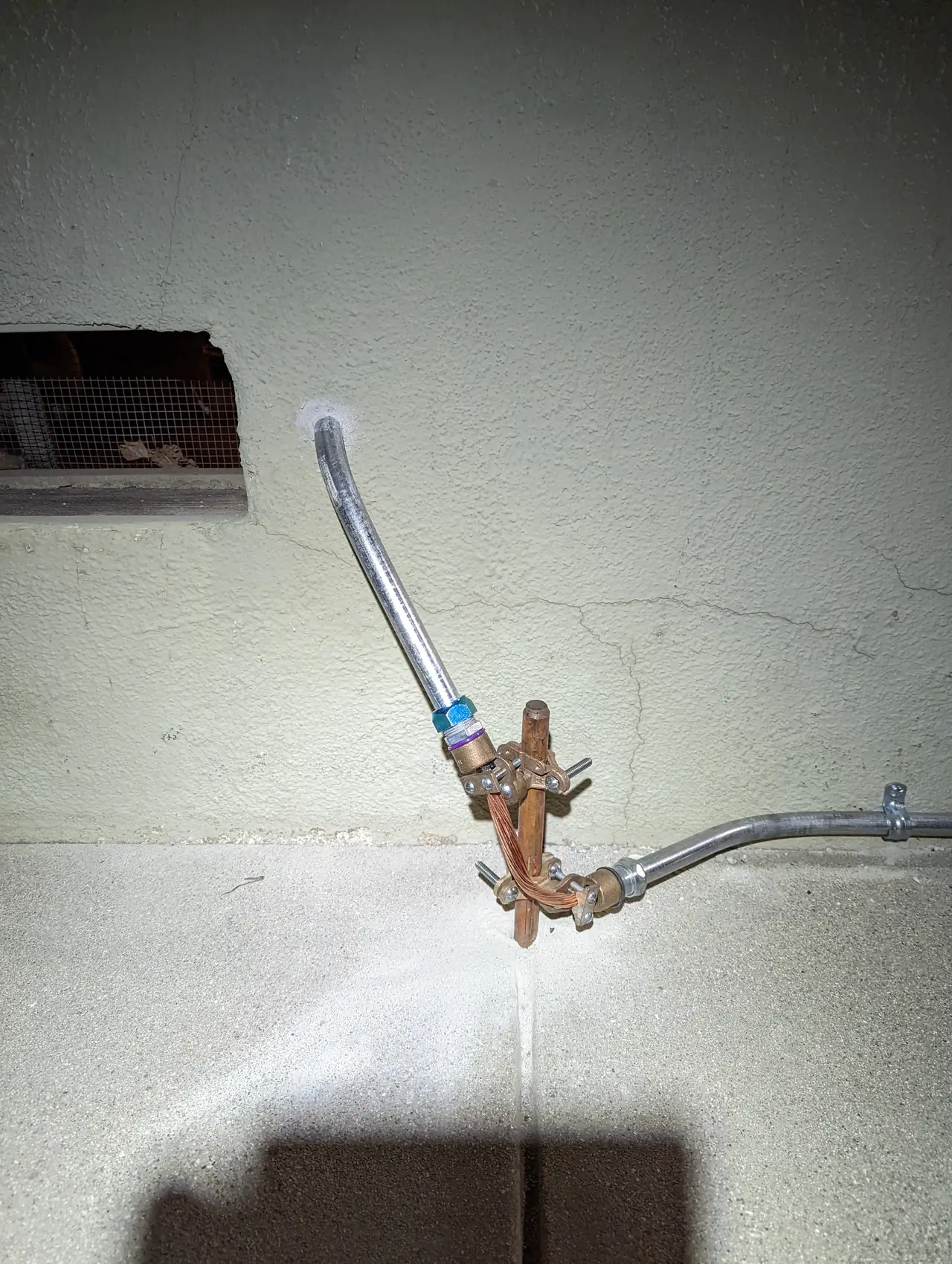Bonding clamp on a water pipe at the base of a wall, Northridge