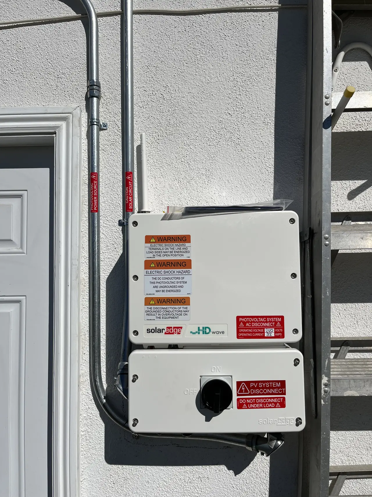 String inverter and disconnect mounted beside a door, Northridge