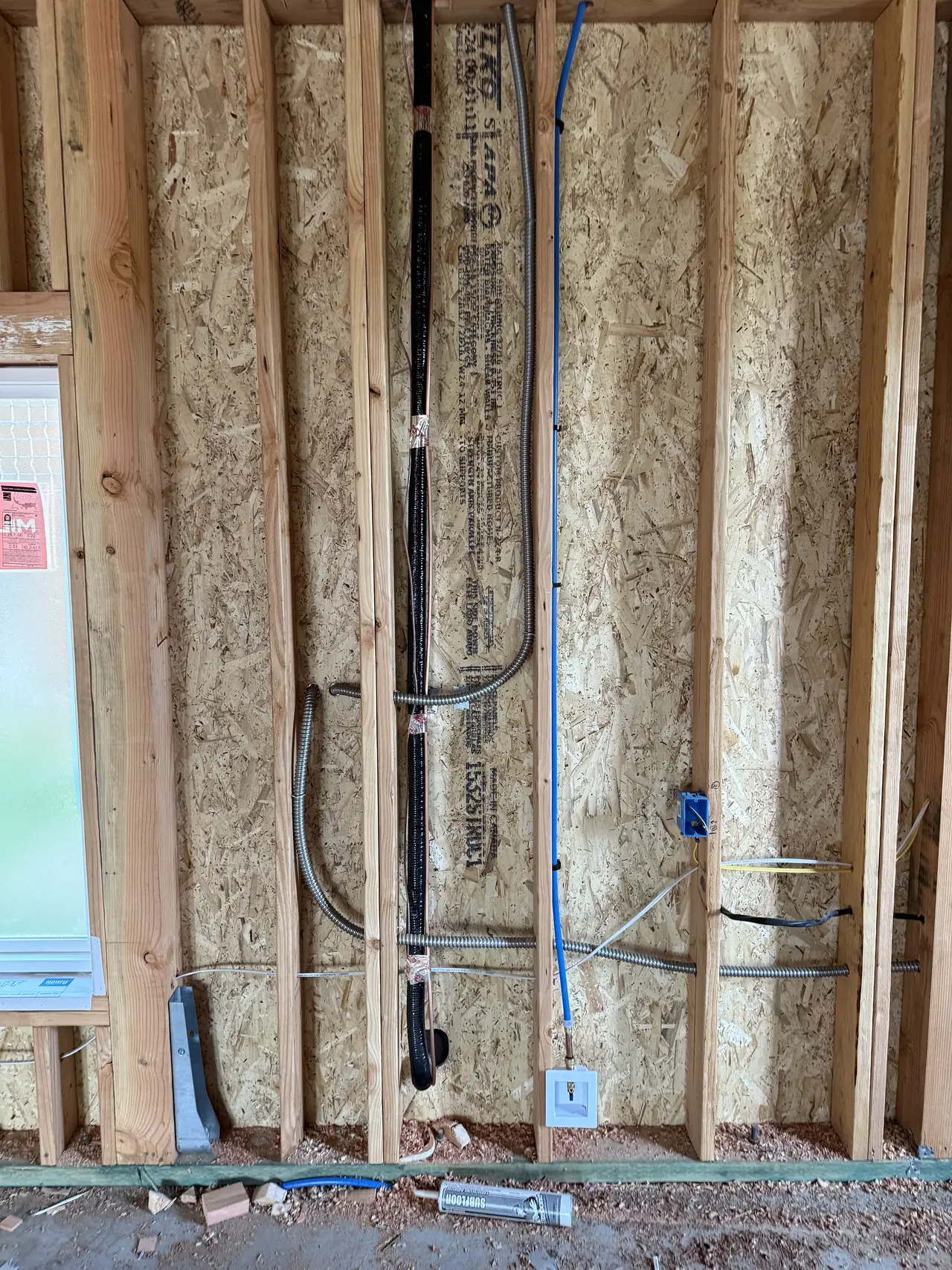 Conduit and cabling run inside open stud framing during construction, Northridge