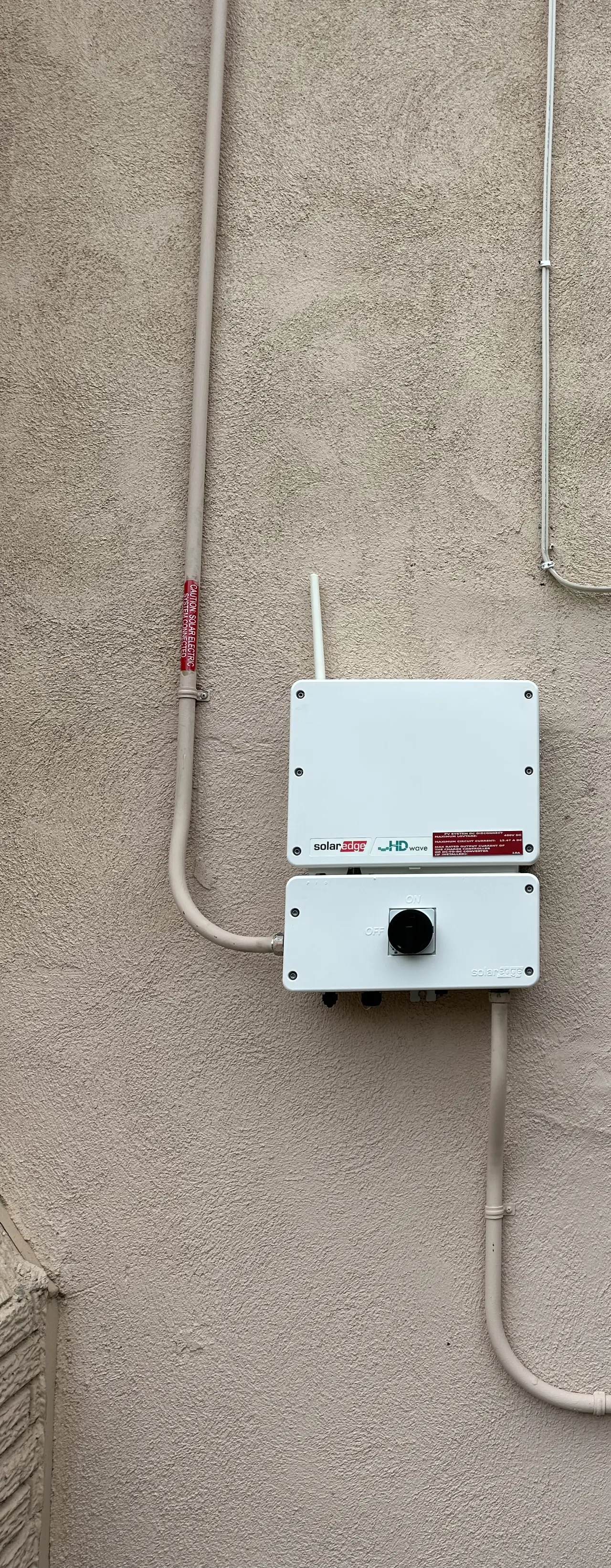 String inverter mounted on a stucco wall with conduit, Northridge