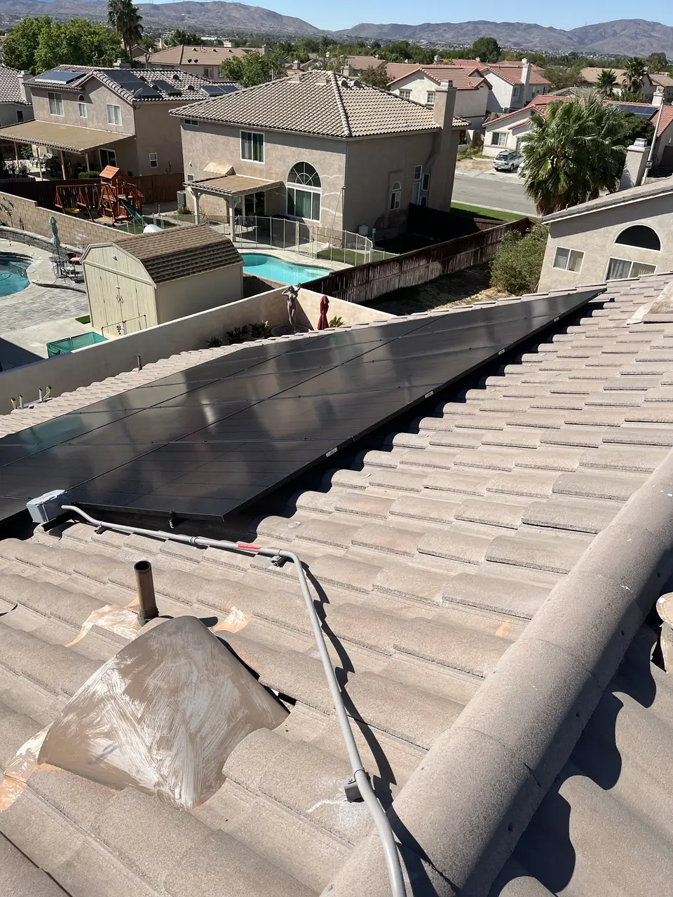 All-black solar array with Enphase microinverters on concrete tile in Palmdale