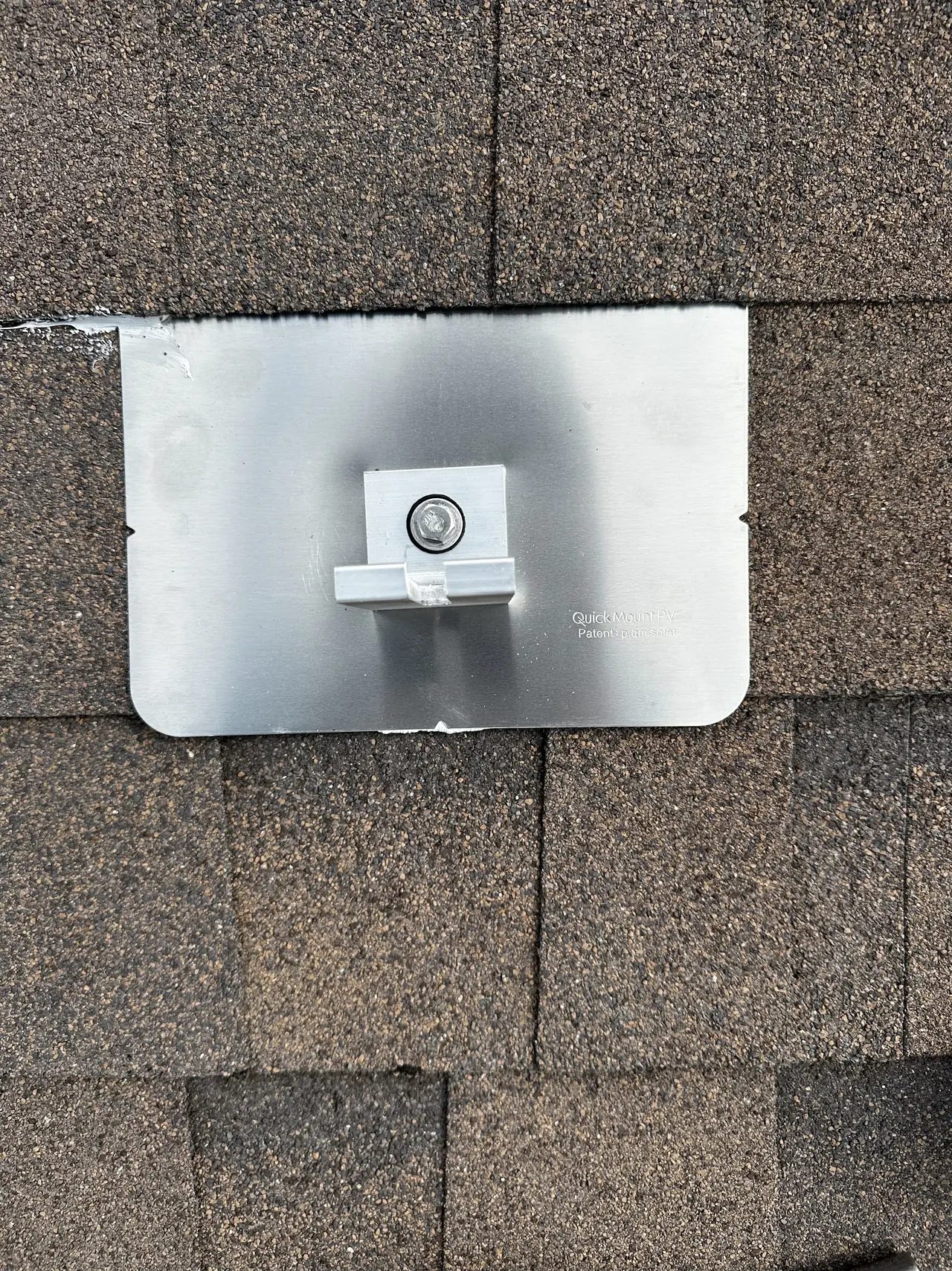 A metal flashing plate slipped under a course of composition shingle with a standoff and a sealed collar rising through it, Panorama City
