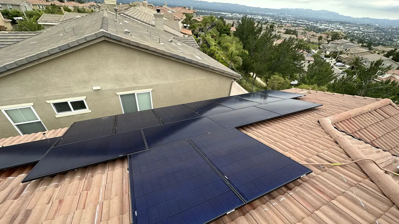 A solar array spread across two tile roof planes above the valley, Porter Ranch