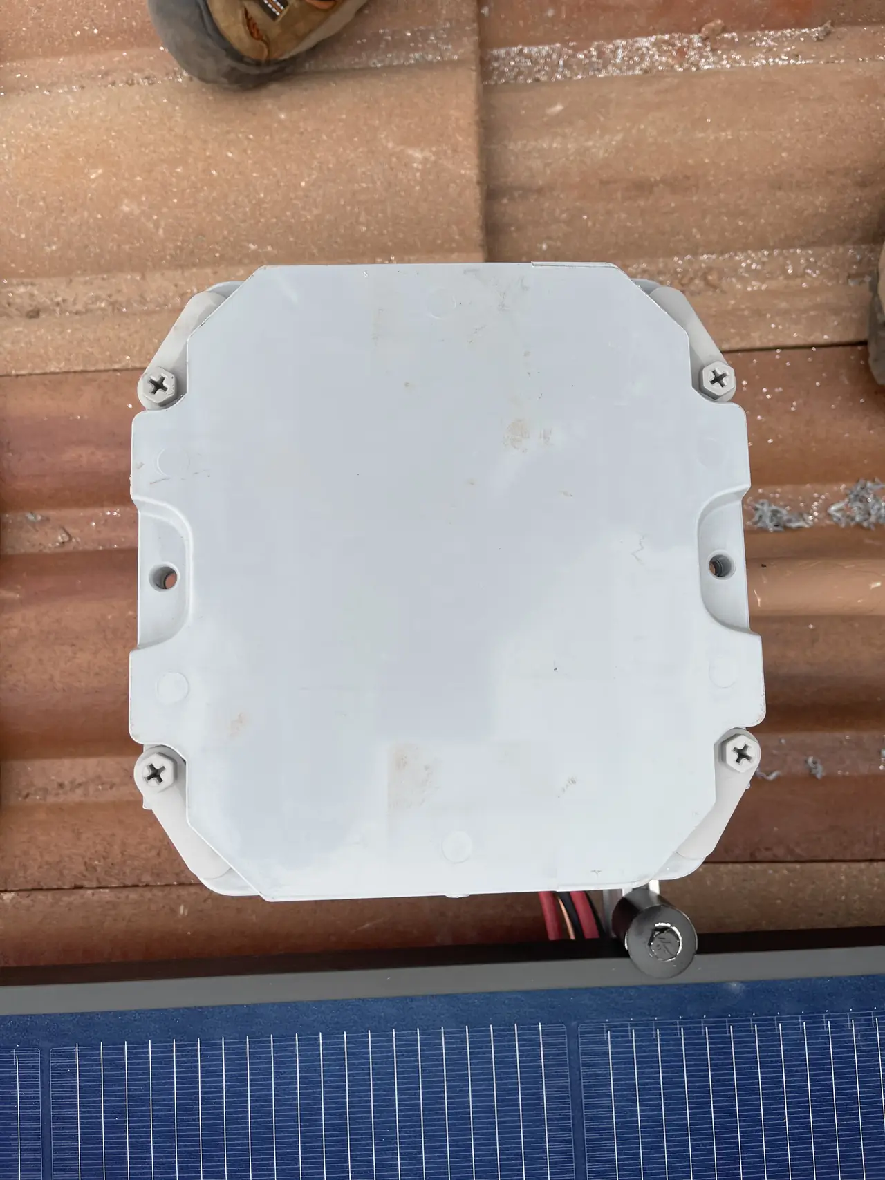 A closed junction enclosure set among the modules on a tile roof, Porter Ranch