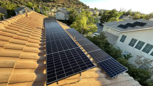 A large solar array on a tile roof with hills and the tract beyond, Porter Ranch