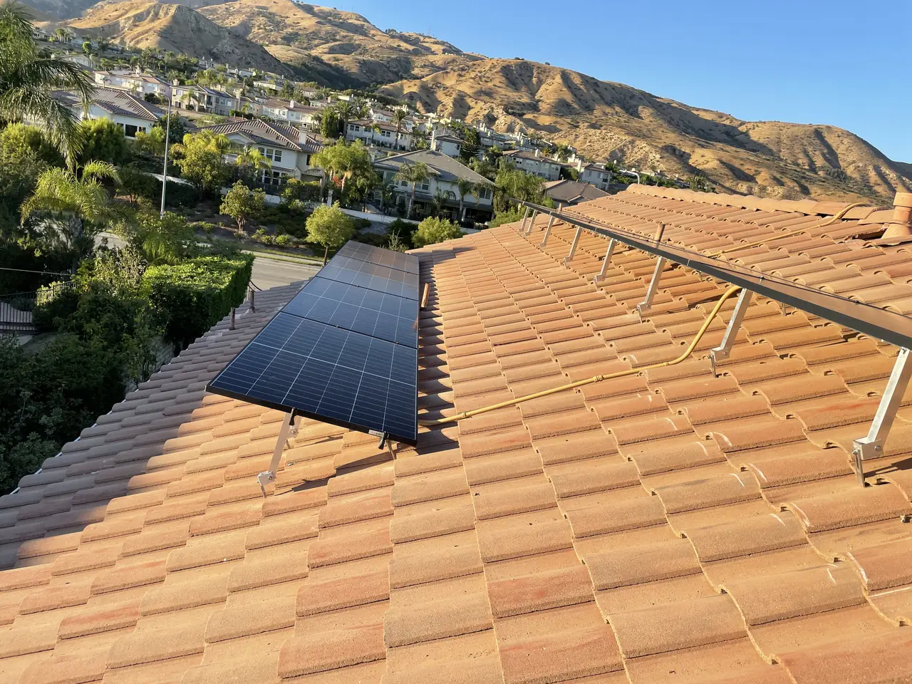Modules going down on a tile roof with rails and conduit already run, Porter Ranch