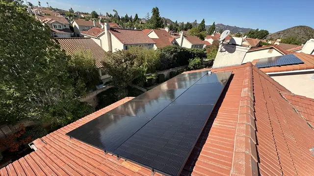 Nine solar modules on a red tile roof with the tract and hills beyond, Porter Ranch