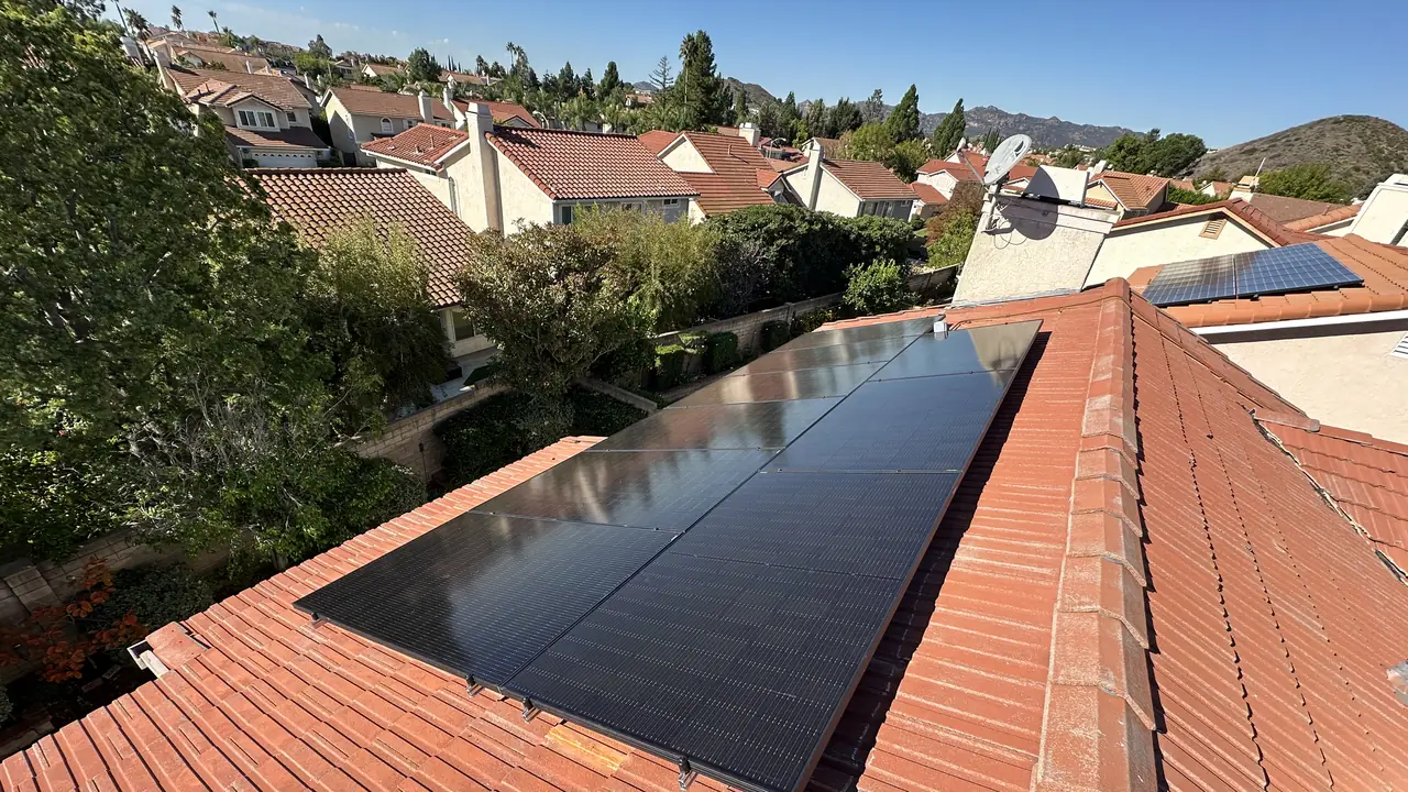 Nine solar modules on a red tile roof with the tract and hills beyond, Porter Ranch