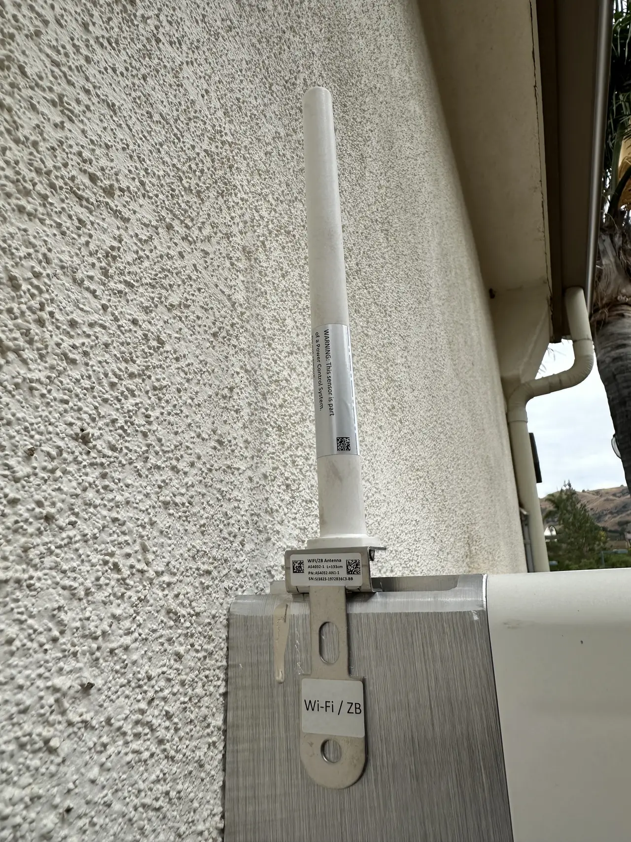 A communications antenna mounted on a stucco wall under the eave, Porter Ranch