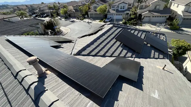 Solar modules on the rear planes of a tile roof above a tract street, Porter Ranch