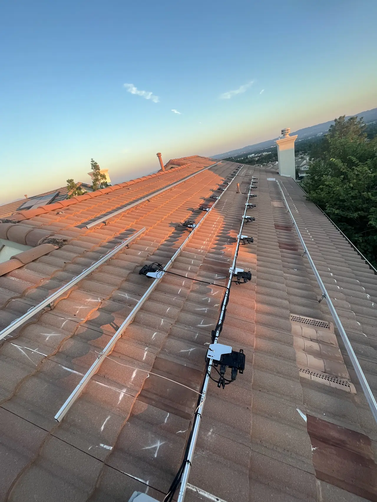 Mounting rails fixed across a tile roof at dusk, Porter Ranch