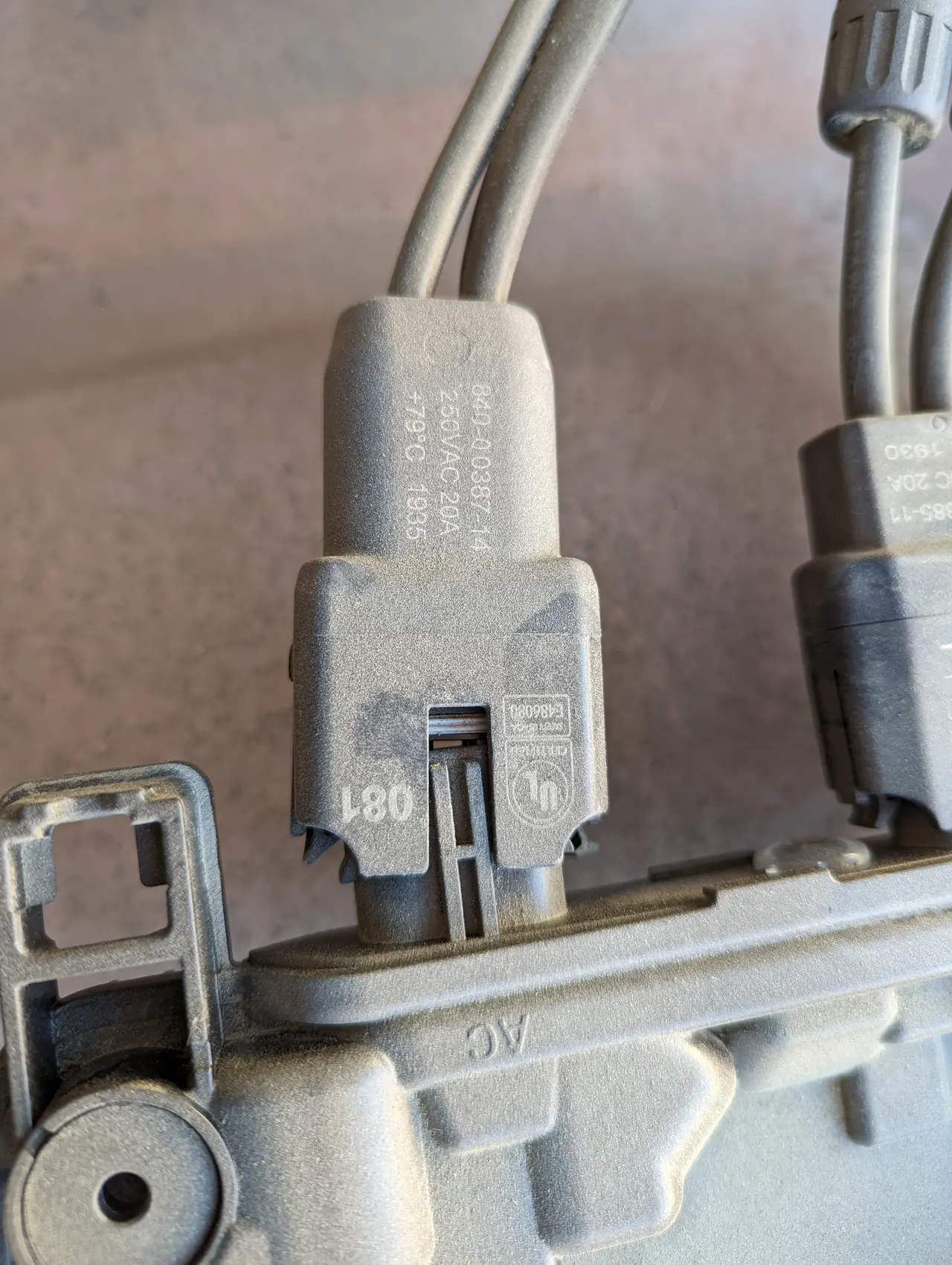 A microinverter and its cables held beside the mounting rail, Porter Ranch