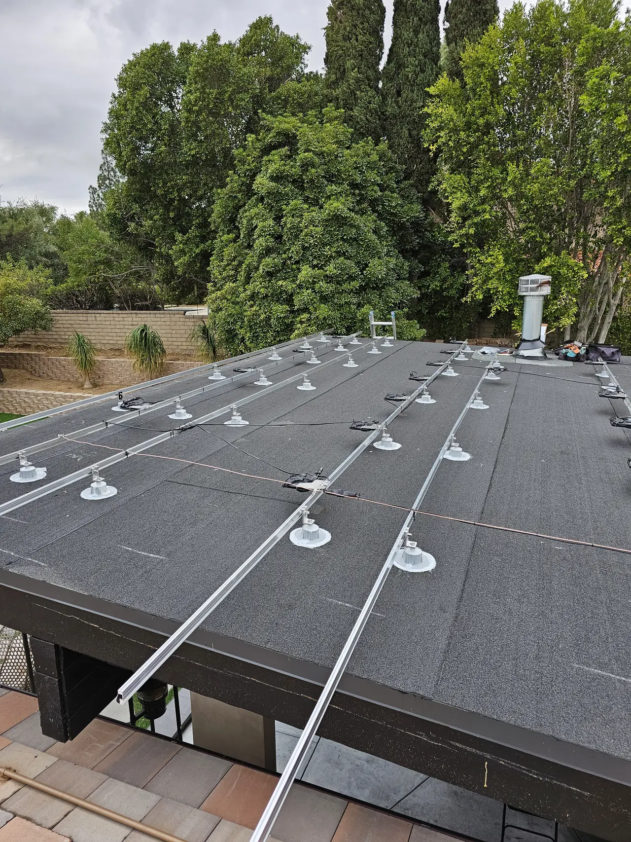 Mounting rails and feet laid out across a low-slope roof section, Porter Ranch